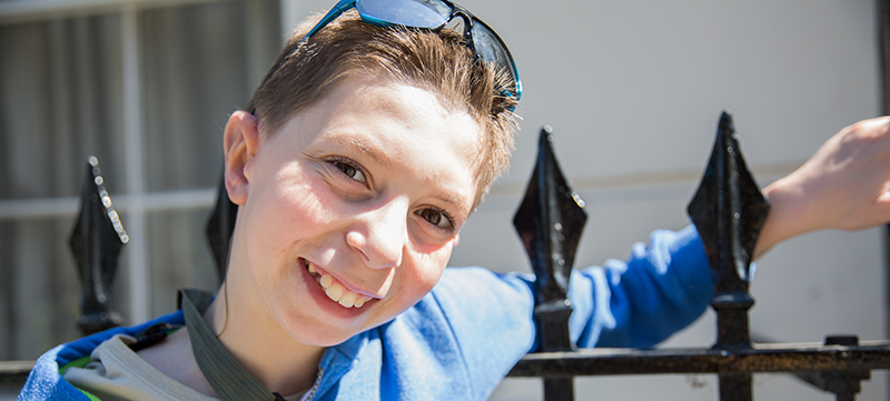 Photo of Kieran, smiling and wearing sunglasses atop his head. His new right ear is visible.