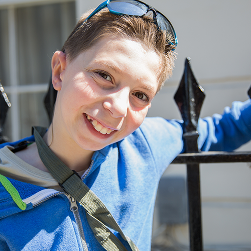 Photo of Kieran, smiling and wearing sunglasses atop his head. His new right ear is visible.