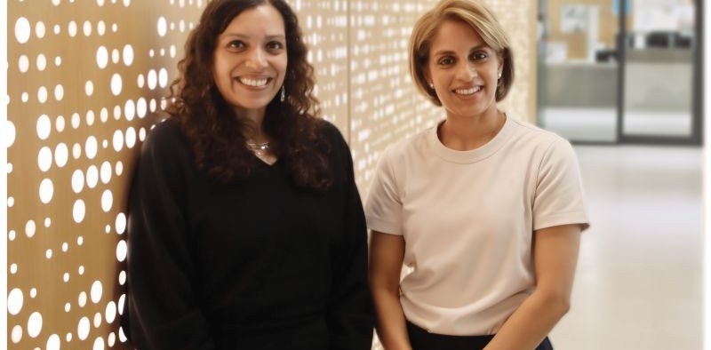 Two women smile at the camera