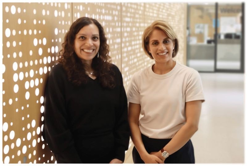 Two women smile at the camera