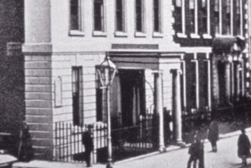 Black and white street view photo of original Great Ormond Street Hospital building with signage reading "Hospital for Sick Children"
