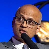 A man with glasses speaking into a microphone