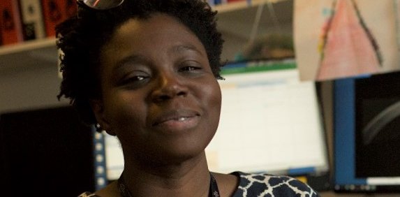 A Black woman smiles at the camera