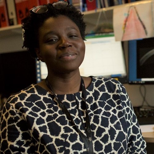 A Black woman smiles at the camera