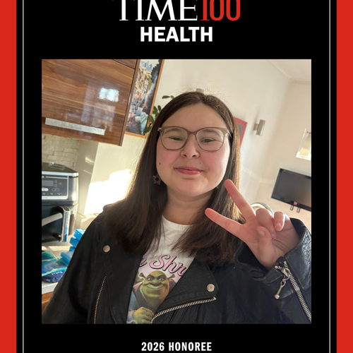 A red and black framed picture of a young woman smiling at the camera holding up two fingers in the 'peace' sign