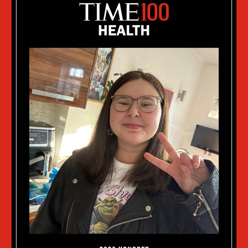 A red and black framed picture of a young woman smiling at the camera holding up two fingers in the 'peace' sign