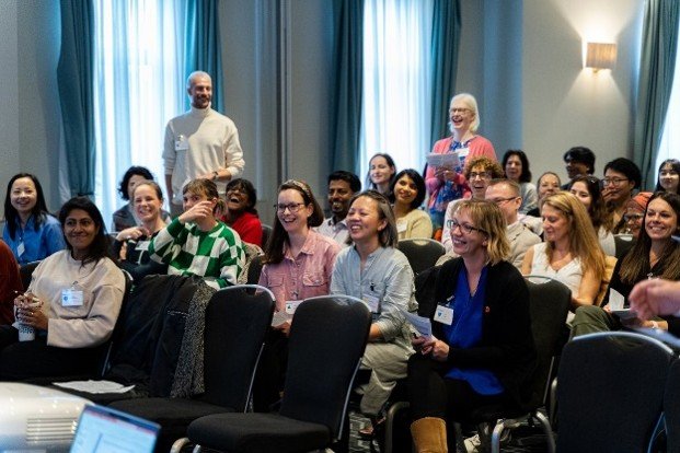 A large group of happy people line up posing for a photograph