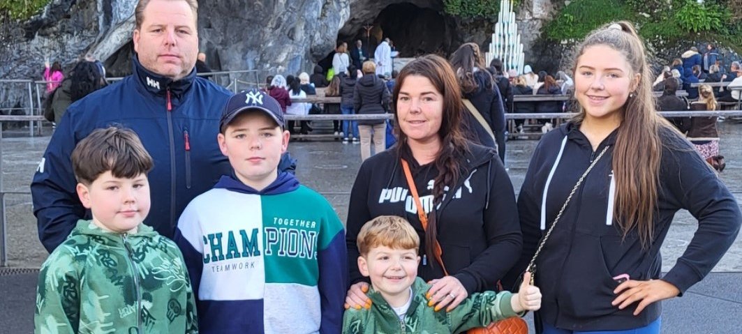 A boy stood with his mum, dad, two brothers and sisters