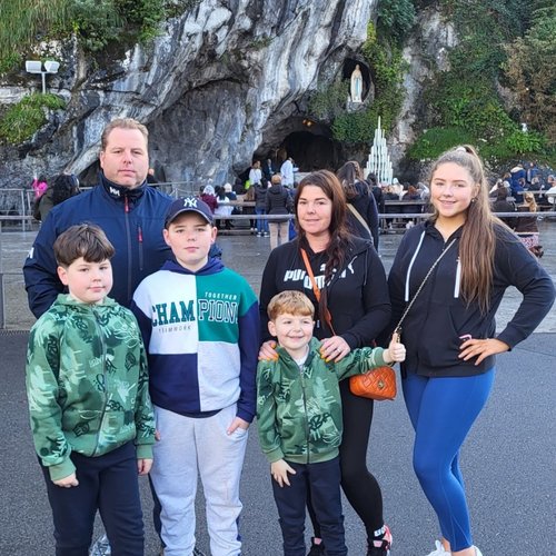 A boy stood with his mum, dad, two brothers and sisters