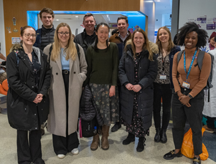 A group of people stand posed for the camera, smiling broadly.