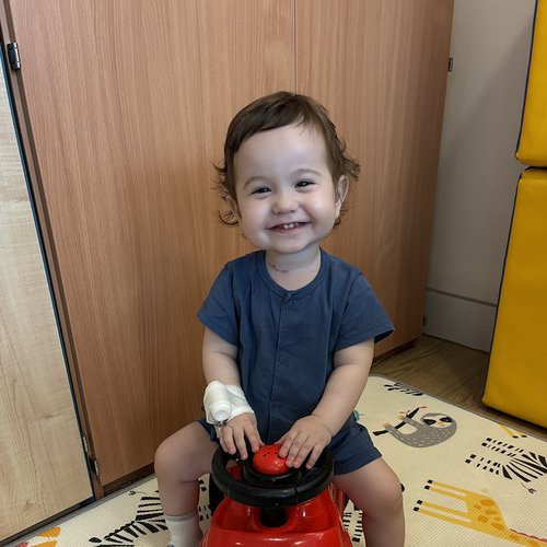 A young boy smiles broadly at the camera