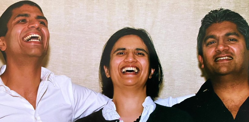 Three siblings hug and smile, all of them doctors.