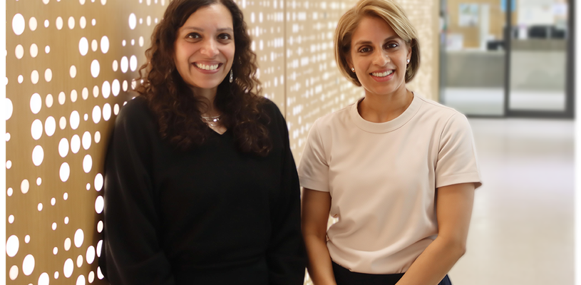 Two women smile at the camera