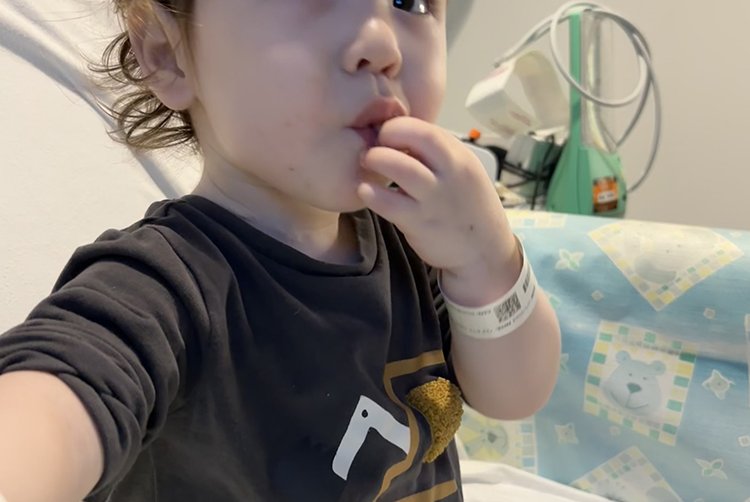 A little boy sitting on a hospital bed