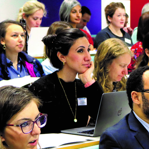 A photo of a lecture theatre full of people with laptop and notebooks
