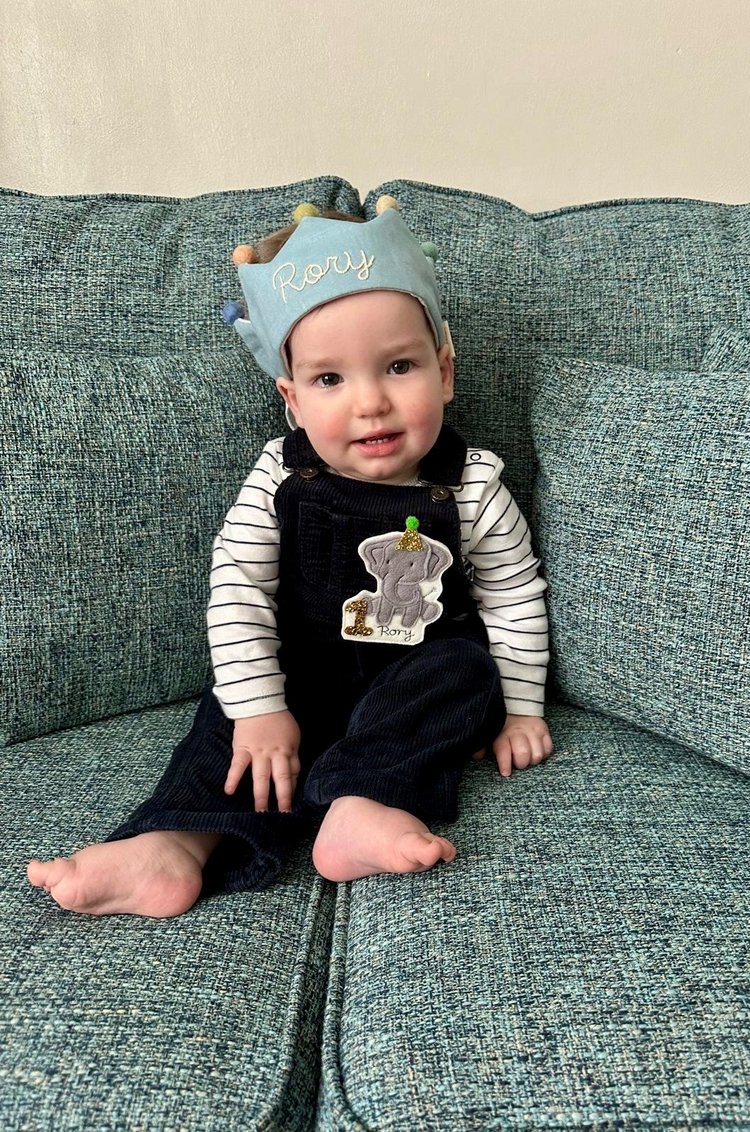 Little boy with brown hair sat on sofa