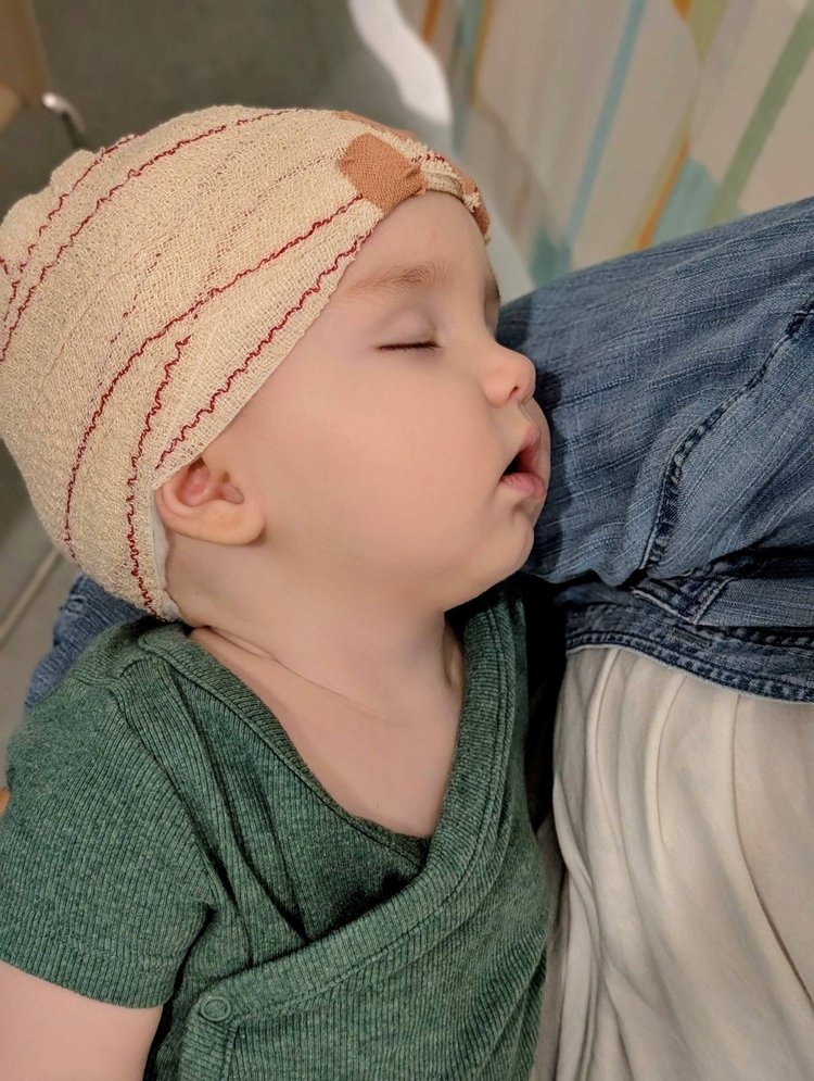 Boy sleeping with bandage on his head