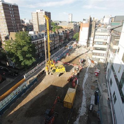 A construction site from above with machinery. There is a gap in the buildings where a GOSH building has been deconstructed.