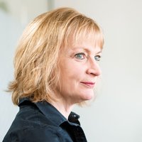 A woman with short blonde hair is smiling