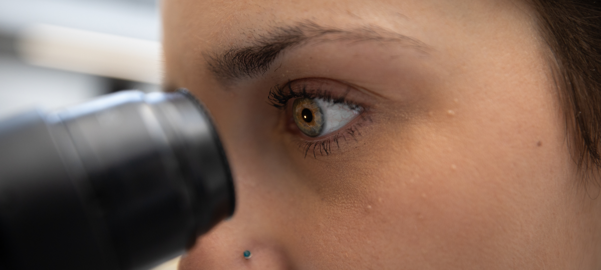 Eye looking into microscope