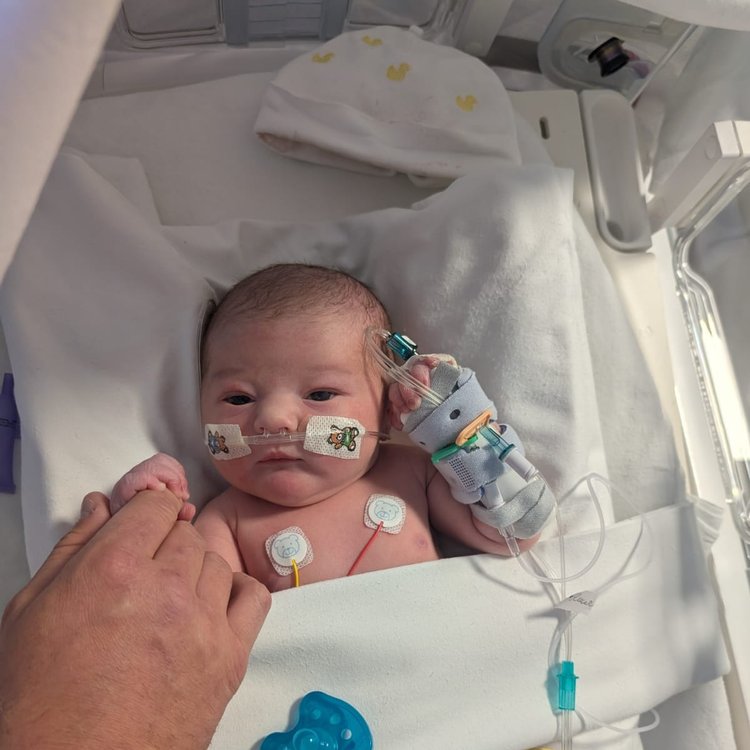 Baby in hospital cot