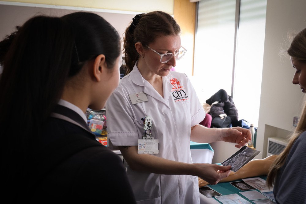 Two students looking at a scan image that a clinician is showing them