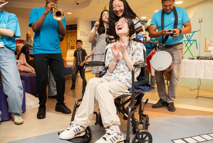A patient in a wheelchair is laughing