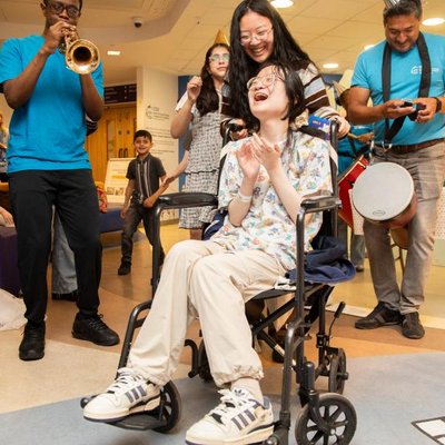 A patient in a wheelchair is laughing