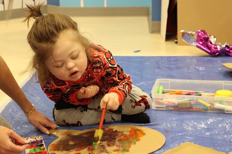 A child sitting on the floor painting