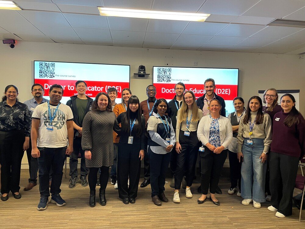 A group of students stood in a classroom smiling