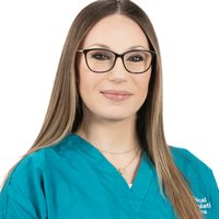 A woman with long brown hair, glasses and a blue top is smiling.