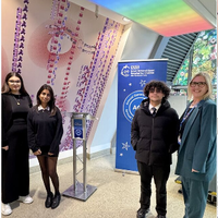 Four people standing in front of a blue banner.