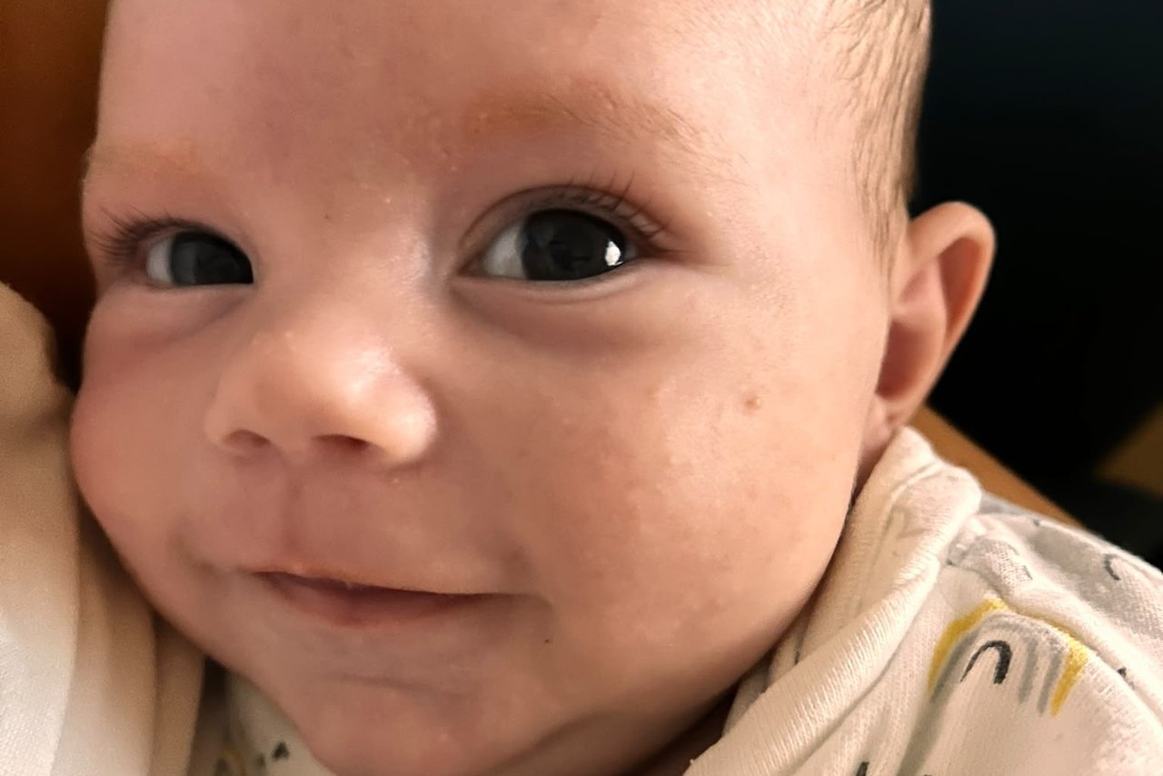 A baby smiles at the camera