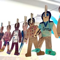 A line of paper gingerbread people, pegged up on a washing line.