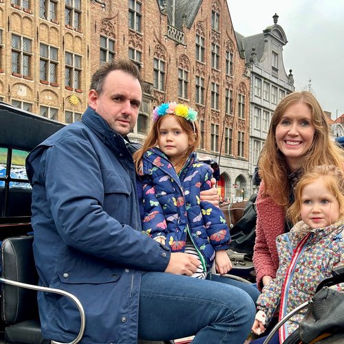 Lucia's dad is sitting next to Lucia with her mum sitting next to her sister in a carriage
