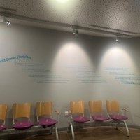 A light grey wall with teal text displaying Great Ormond Street Hospital poem. Seats in front.