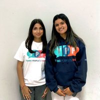 Two young women, smiling, wearing a tshirt and a hoody with 'YPF' on