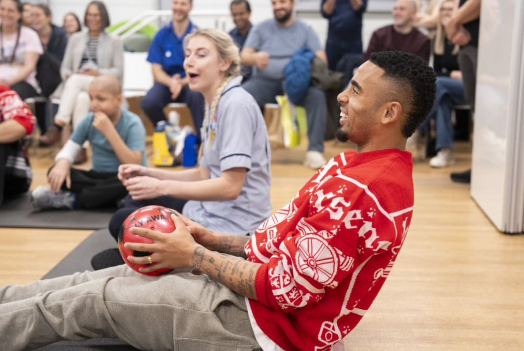 arsenal player sat in physio gym catches football
