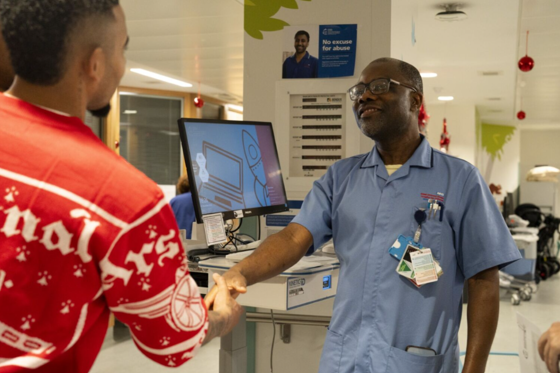 arsenal player shaking hands with staff member on ward
