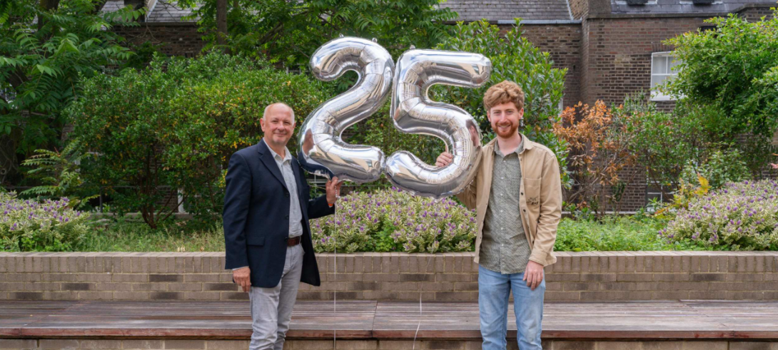 Large balloons of number 25 and two men standing either side, Adrian Thrasher left, Rhys right