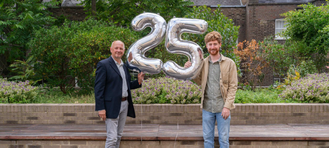 Large balloons of number 25 and two men standing either side, Adrian Thrasher left, Rhys right