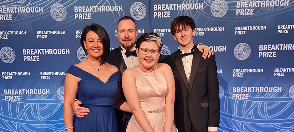 A family dressed up for a special occasion smile at the camera