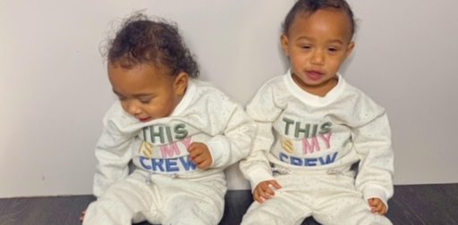 Amelia and her twin sister Lily sitting down and smiling